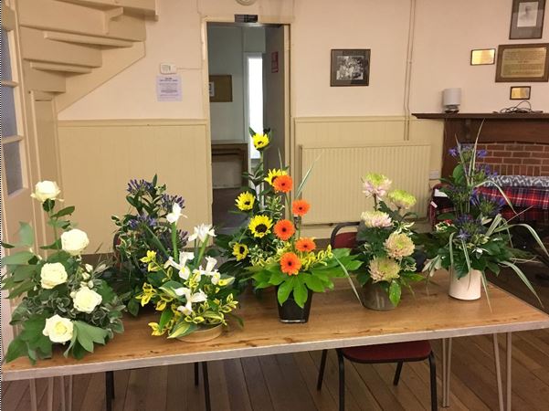 An collection of nicely arranged flowers in pots on a table